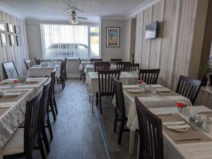 斯凯格内斯The Ivernia hotel的餐厅内带桌椅的用餐室