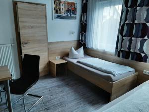 博尔兴Haus Roseneck-Pension Am Stadtrand的小房间设有一张床和一把椅子