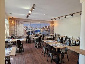 贝桑于潘港艾森豪威尔酒店（前国王酒店）的餐厅设有桌椅和大窗户。