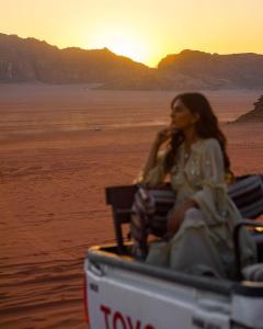 瓦迪拉姆Hasan Zawaideh Camp的坐在海滩上公共汽车上的女人