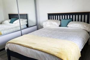 弗萨Aghadoe Millers - Modern 3 bed house Killarney的一间卧室配有两张带枕头和镜子的床