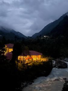 PhakdingMountain Lodges of Nepal - Phakding的河边有灯的房子