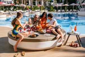 马贝拉Hard Rock Hotel Marbella - Puerto Banús的一群人坐在泳池旁的热水浴缸中