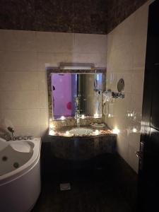 艾卜哈Samaa Eva Resort的带浴缸和盥洗盆的浴室以及窗户