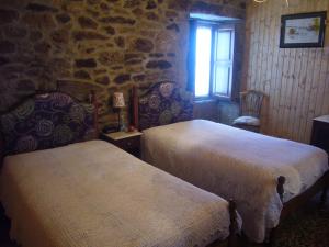 LeomilCasa do Monge的石墙客房的两张床