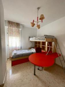 塞维利亚Magnífico Apartamento en Sevilla的卧室配有红色桌子和双层床。