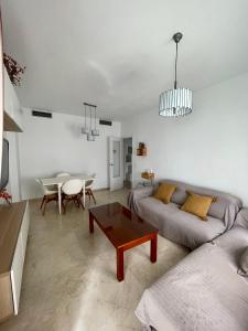 塞维利亚Magnífico Apartamento en Sevilla的客厅配有沙发和桌子
