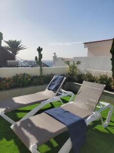 卡亚俄萨尔瓦赫Villa Sunrise with heated pool.的两把躺椅和一条毛巾坐在草地上