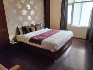 斯利那加Hotel Green Leaf , Srinagar的窗户客房内的一张大床