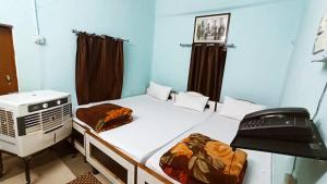 王舍城ANAND LOK VATIKA的客房设有两张床、一台微波炉和加热器