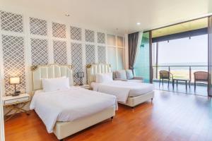 佛丕Sea Sand Sun Hua Hin Resort的酒店客房设有两张床和一个阳台。