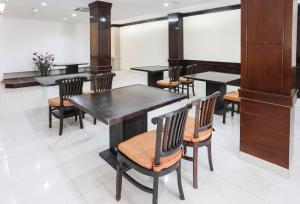 雅加达Townhouse Oak J&b Gunung Sahari的用餐室配有黑色的桌椅