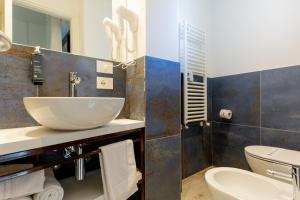 里乔内Hotel Grazia Riccione的一间带水槽和卫生间的浴室