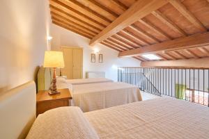 波普洛尼亚Poggio all'Agnello Sport & Active Holidays的一间设有三张床和一张带台灯的桌子的房间