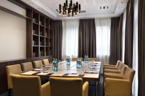 美因河畔法兰克福Flemings Selection Hotel Frankfurt-City的一间会议室,配有长桌子和椅子