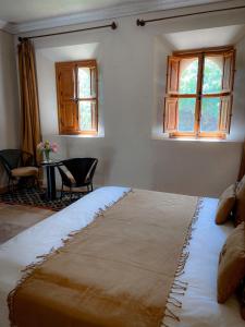 Oulad Mazoug迈丹艾尔艾尔莎旅馆的卧室配有床、桌子和窗户。