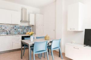 马里蒂玛Corte dei Fiori Acquaviva Apartments的厨房配有桌子和蓝色的椅子