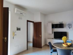 马里蒂玛Corte dei Fiori Acquaviva Apartments的一间带桌子的房间和一间带饭厅的厨房