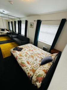 利物浦Liberty Inn Room with sharing toilet and kitchen的一间卧室配有一张床、一张沙发和一面镜子