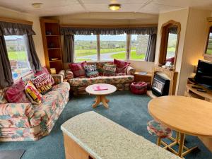普尔赫利Snowdon Bay - North Wales - Stunning Llyn Peninsula Mountain & Ocean Views的客厅配有沙发和桌子