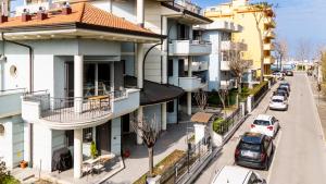里乔内Appartamenti Desi Riccione的公寓大楼的街道上设有停车位