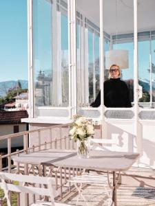 吉法Venegoni Maison De Charme的坐在窗外阳台的女人