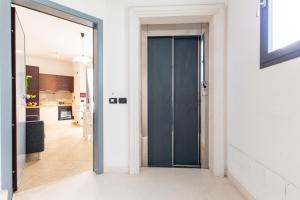 里乔内Appartamenti Desi Riccione的通往厨房的带蓝色门的走廊