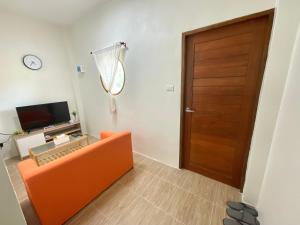 班拉克海滩Yourbed & House的客厅配有橙色沙发和门