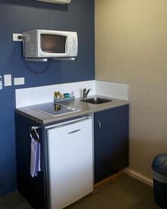 新普利茅斯兰德马克庄园酒店的一间带水槽和微波炉的小厨房