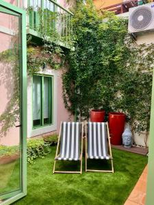 辛特拉Sintra Green Chalet Bed & Breakfast的两把躺椅坐在大楼前的草地上