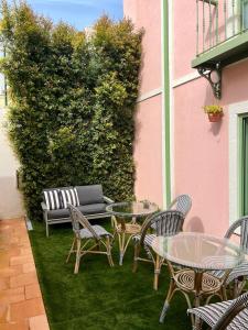 辛特拉Sintra Green Chalet Bed & Breakfast的粉红色建筑前方带桌椅的庭院