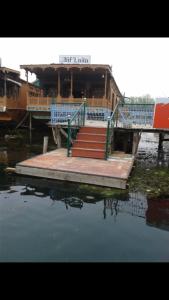 斯利那加Aliflaila Laila Group of Houseboats , Srinagar的一座带楼梯和码头的楼房