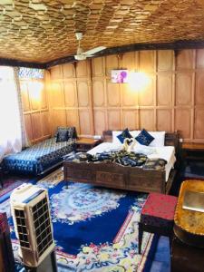 斯利那加Aliflaila Laila Group of Houseboats , Srinagar的客房设有床、沙发和桌子。