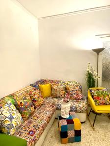 巴勒莫Casa Graziusa的客厅里设有色彩缤纷的沙发,还有一只猫坐在凳子上