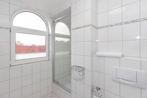 奥斯赛拜-屈隆斯博恩Strandschloesschen-I-WE-21-684的白色的浴室设有窗户和淋浴。