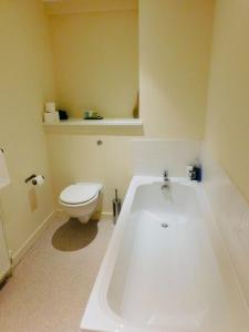 佩斯利Modern 2 Bed Apartment Close to Gla Airport & M8的浴室配有白色浴缸和卫生间。