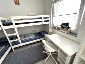斯洛文尼亚比斯特里察OM Yoga center的一间卧室配有两张双层床和一张书桌