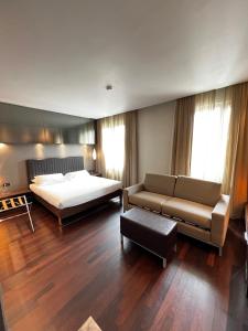 坎图Axolute Comfort Hotel Como - Cantù的一间大卧室,配有一张床和一张沙发