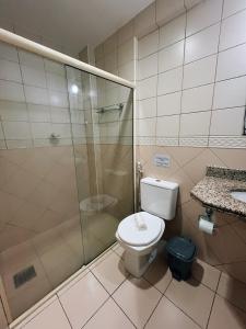 马卡埃Flat Exclusivo no Crystal Apart Hotel!的一间带卫生间和玻璃淋浴间的浴室