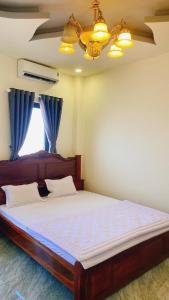 波来古市SAIGON - PLEIKU HOTEL的一间卧室配有一张带蓝色窗帘的大床