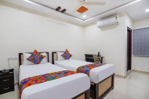 海得拉巴Sree Karthikeya Suites的白色墙壁客房的两张床