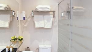 巴塞罗那Hotel Coronado的带淋浴、卫生间和毛巾的浴室