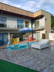巴拉奈里奥-坎布里乌Morada Stucchi的一座带遮阳伞的游泳池的房子