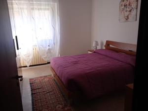 诺瓦拉La casa di Lucia Appartamento的一间卧室设有红色的床和窗户。