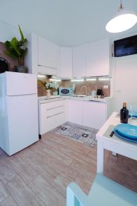 莫诺波利Casa Celeste的厨房配有白色橱柜和白色冰箱。