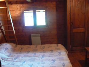 大博尔南Chalet Aravis的一间卧室设有一张床和一个窗口