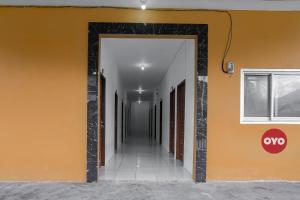 沙马林达Super OYO 92626 Good Sleep 4 Inn Dcos Syariah的走廊上设有橙色墙壁和开放式门