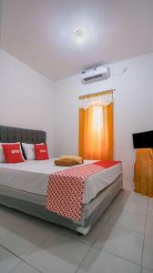 沙马林达Super OYO 92626 Good Sleep 4 Inn Dcos Syariah的一间卧室配有一张带红色枕头的大床