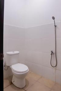 沙马林达Super OYO 92626 Good Sleep 4 Inn Dcos Syariah的白色的浴室设有卫生间和淋浴。