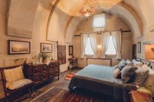 乌奇希萨尔Kale Konak Cappadocia的一间卧室配有一张床、一把椅子和窗户。